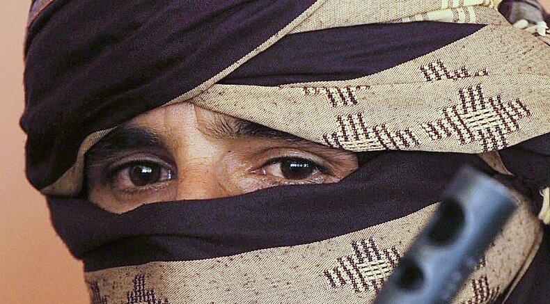 A former Taliban fighter looks on during